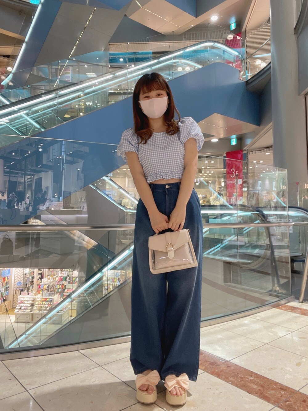 ブルー系のトップス、ブルー系のデニムパンツ、ホワイト系のシューズを着用したレディースの春コーディネートの2枚目の写真