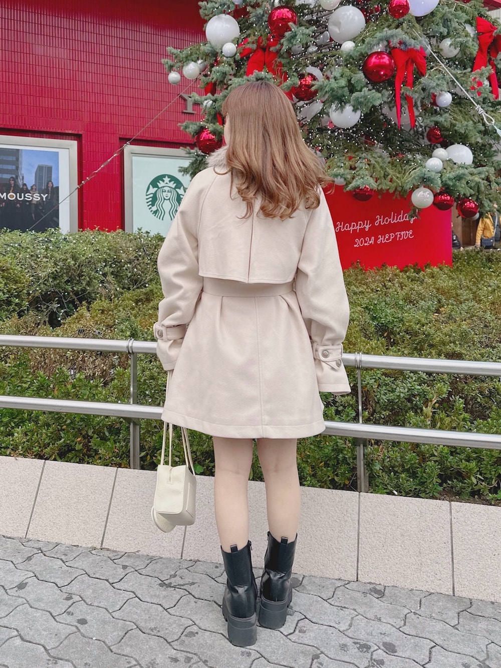 ベージュ系のその他アウター、ブラック系のブーツ、ホワイト系のショルダーバッグを着用したレディースの冬コーディネートの2枚目の写真