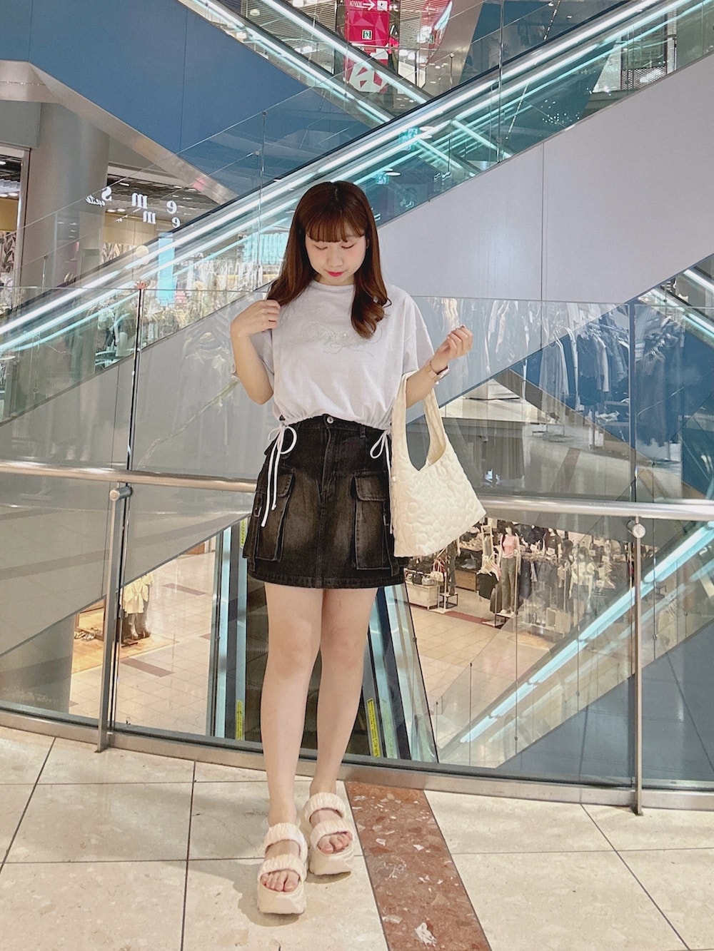 ブルー系のTシャツ/カットソー、ブルー系のスカート、ホワイト系のサンダルを着用したレディースの夏コーディネートの2枚目の写真