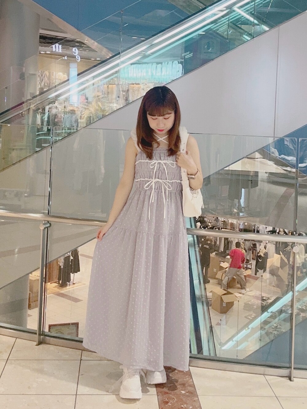 ブルー系のワンピース、ホワイト系のその他シューズ、ホワイト系のショルダーバッグを着用したレディースの春コーディネートの2枚目の写真