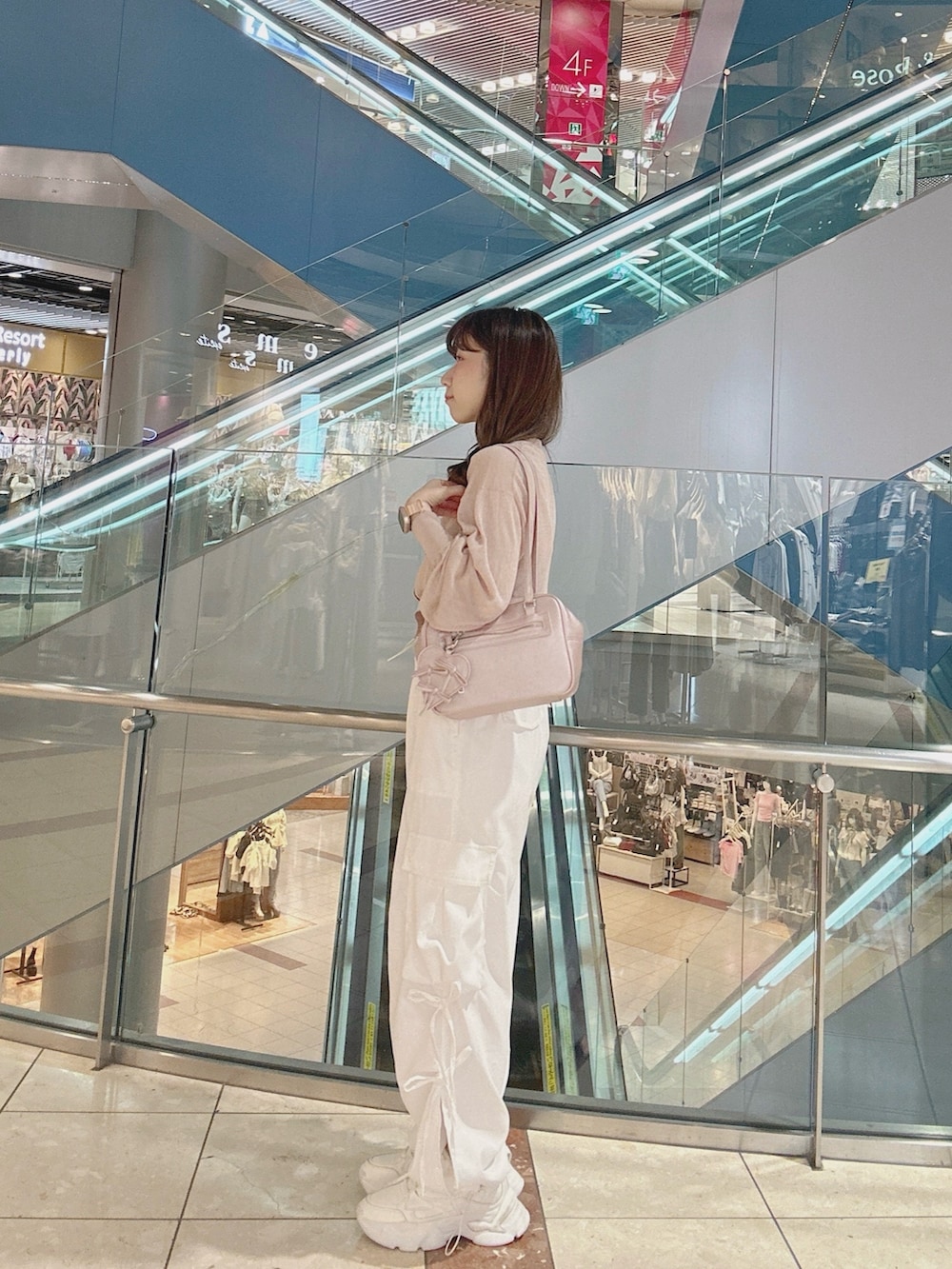 ピンク系のカーディガン/ボレロ、ピンク系のショルダーバッグ、ホワイト系のカーゴパンツを着用したレディースの夏コーディネートの3枚目の写真