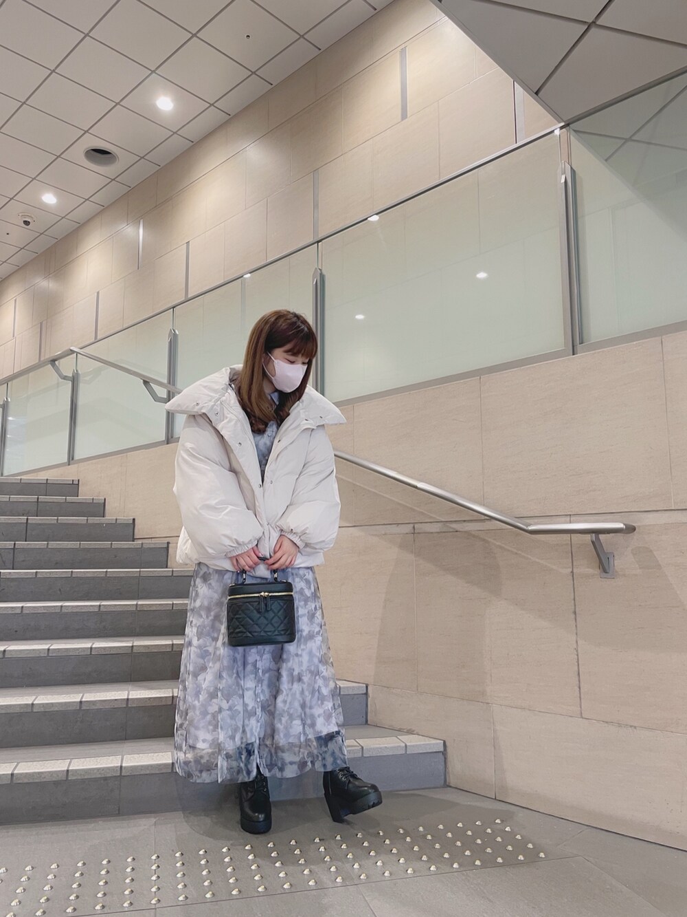 ホワイト系のダウンジャケット/コート、ブラック系のショルダーバッグ、グレー系のワンピースを着用したレディースの冬コーディネートの4枚目の写真