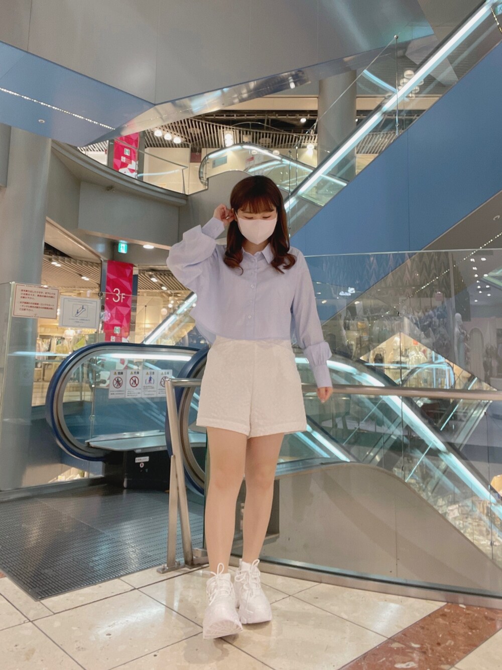 ホワイト系のスニーカー、ブルー系のトップス、ホワイト系のパンツを着用したレディースの春コーディネートの2枚目の写真