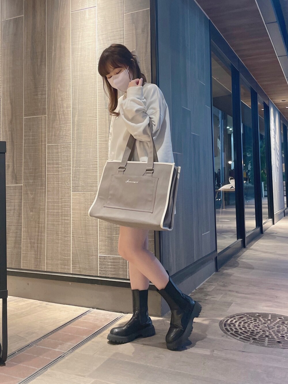 ホワイト系のスウェット、ブラウン系のトートバッグを着用したレディースの冬コーディネートの3枚目の写真