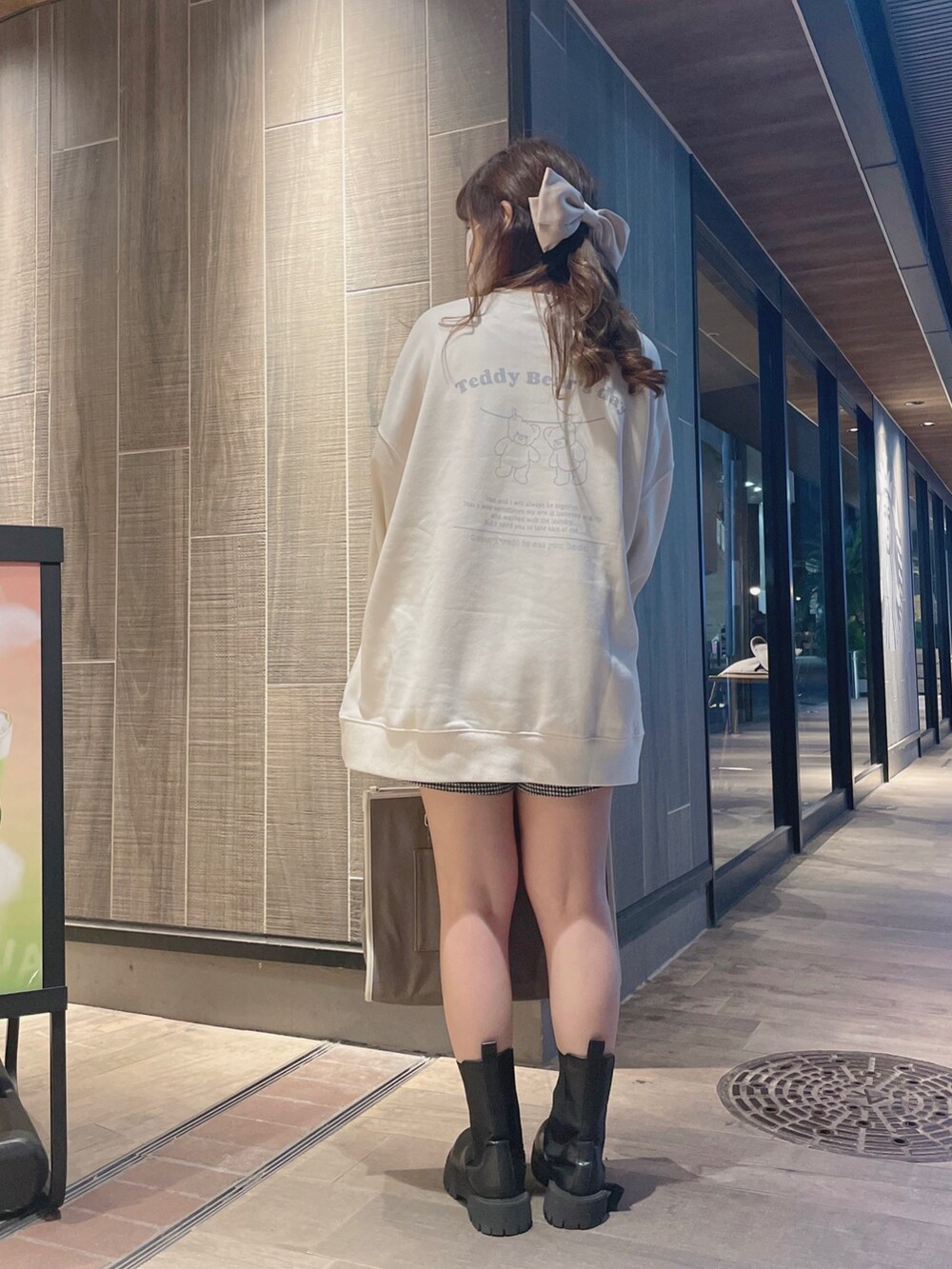 ホワイト系のスウェット、ブラウン系のトートバッグを着用したレディースの冬コーディネートの4枚目の写真