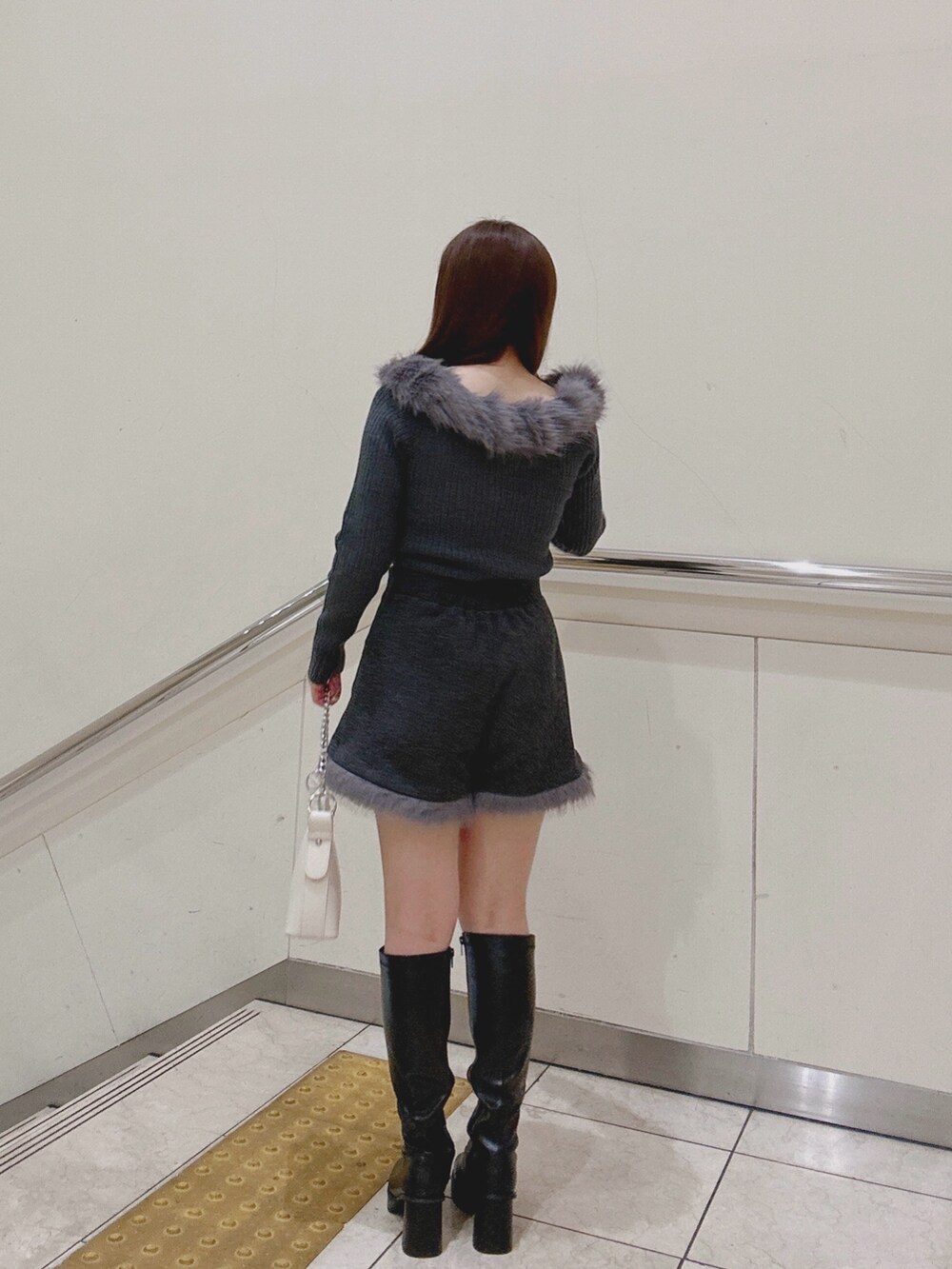 グレー系のニット/セーター、グレー系のその他パンツ、ホワイト系のショルダーバッグを着用したレディースの冬コーディネートの3枚目の写真