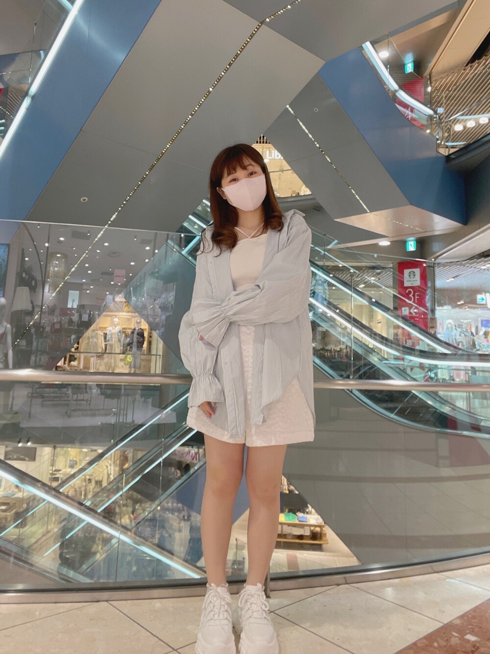 グリーン系のトップス、ホワイト系のパンツ、ホワイト系のキャミソールを着用したレディースの春コーディネートの3枚目の写真