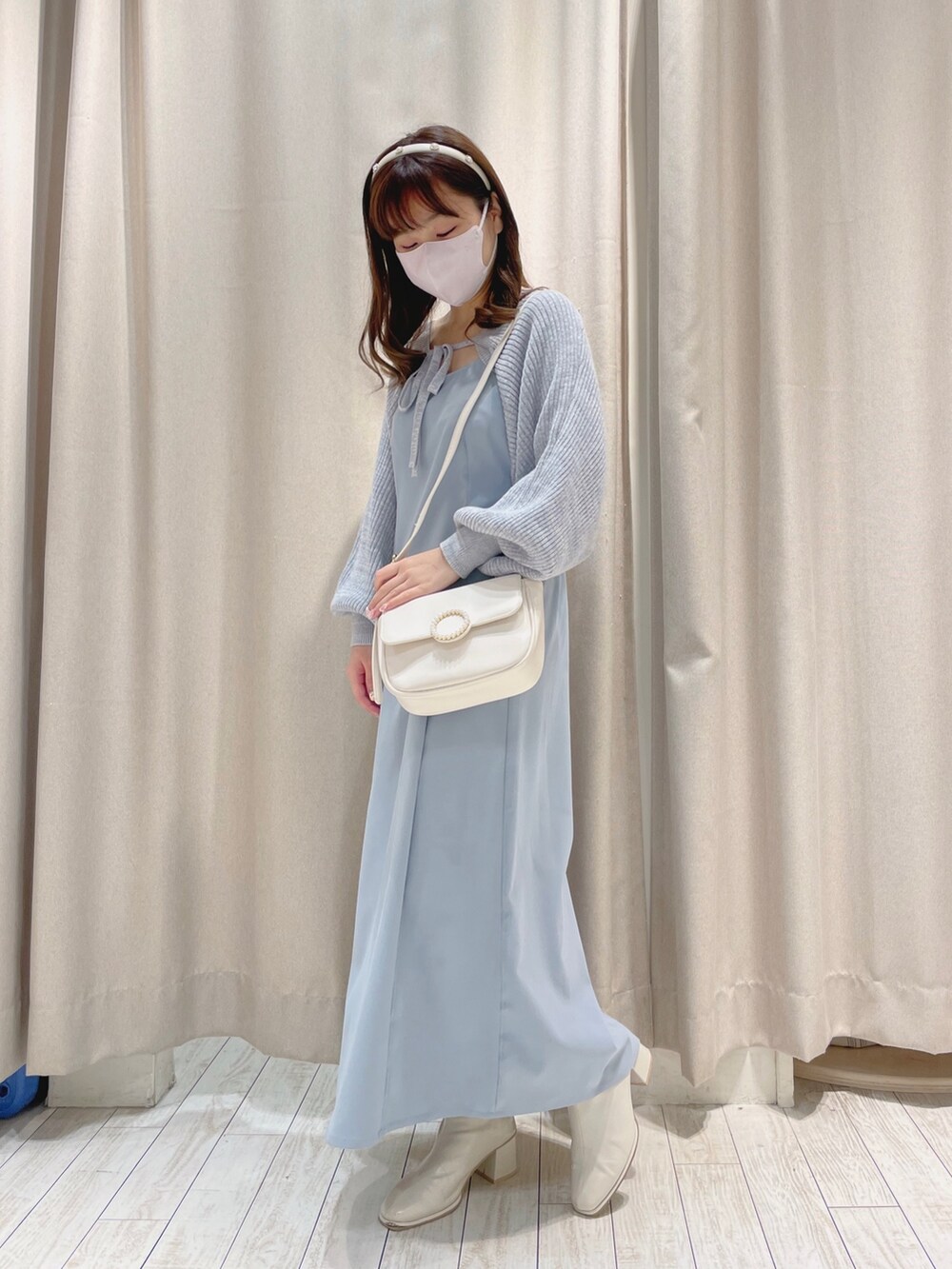 ホワイト系のショルダーバッグ、ブルー系のワンピースを着用したレディースの冬コーディネートの2枚目の写真