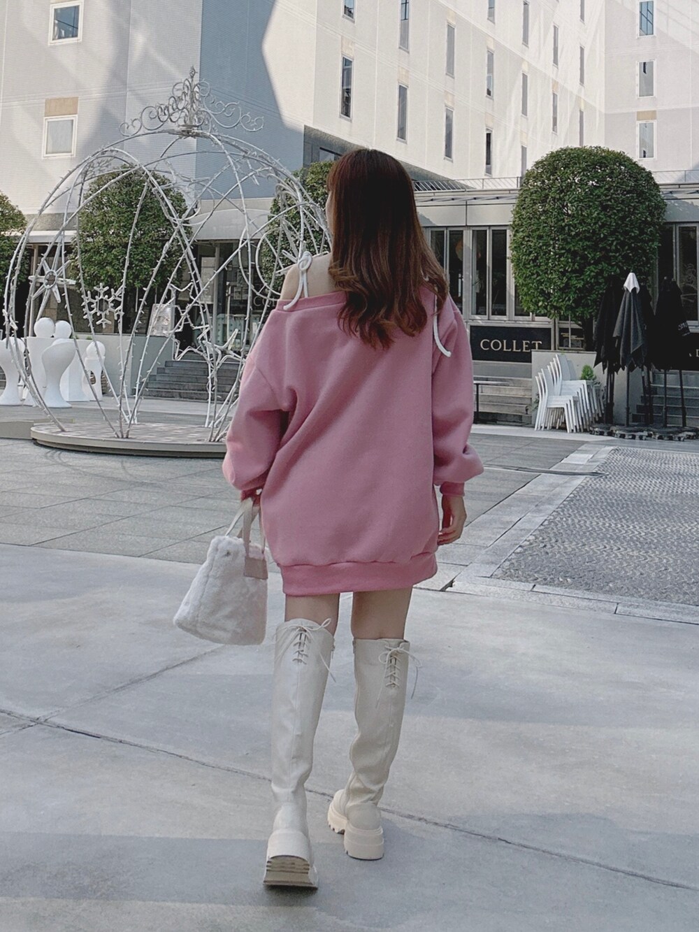 ピンク系のスウェット、ホワイト系のブーツ、ホワイト系のショルダーバッグを着用したレディースの秋コーディネートの3枚目の写真