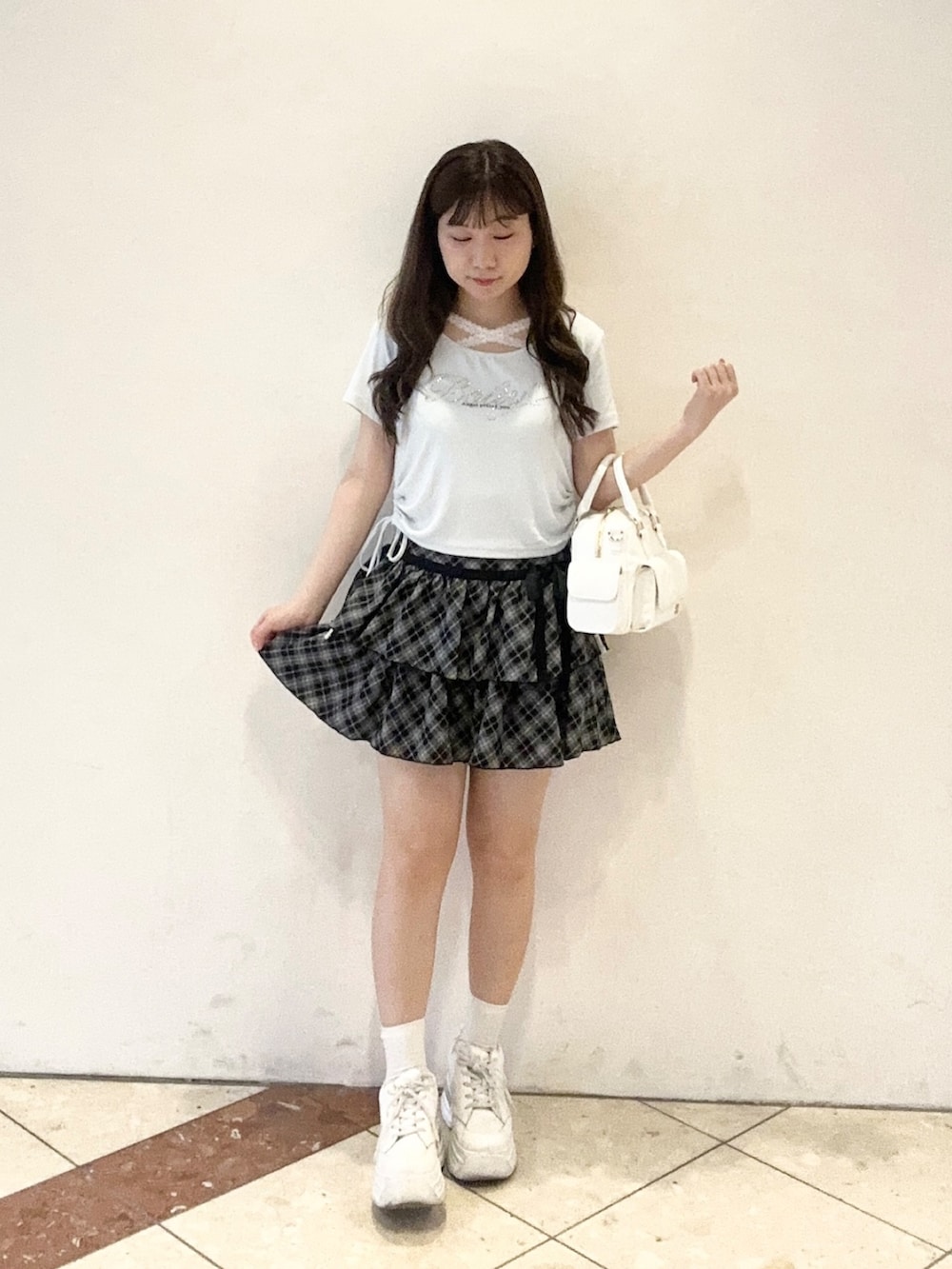 ホワイト系のショルダーバッグ、ブルー系のTシャツ/カットソー、ブラック系のスカートを着用したレディースの夏コーディネートの2枚目の写真