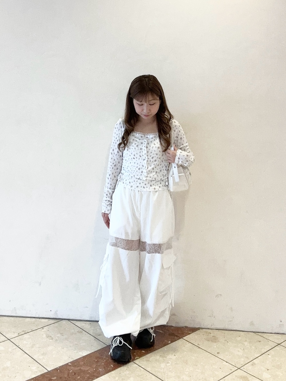 ホワイト系のショルダーバッグ、ホワイト系のカーゴパンツ、ホワイト系のTシャツ/カットソーを着用したレディースの春コーディネートの2枚目の写真