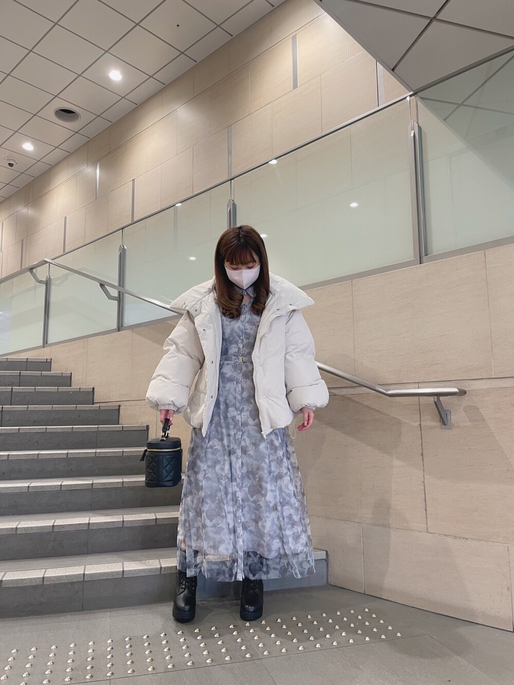 ホワイト系のダウンジャケット/コート、ブラック系のショルダーバッグ、グレー系のワンピースを着用したレディースの冬コーディネートの3枚目の写真