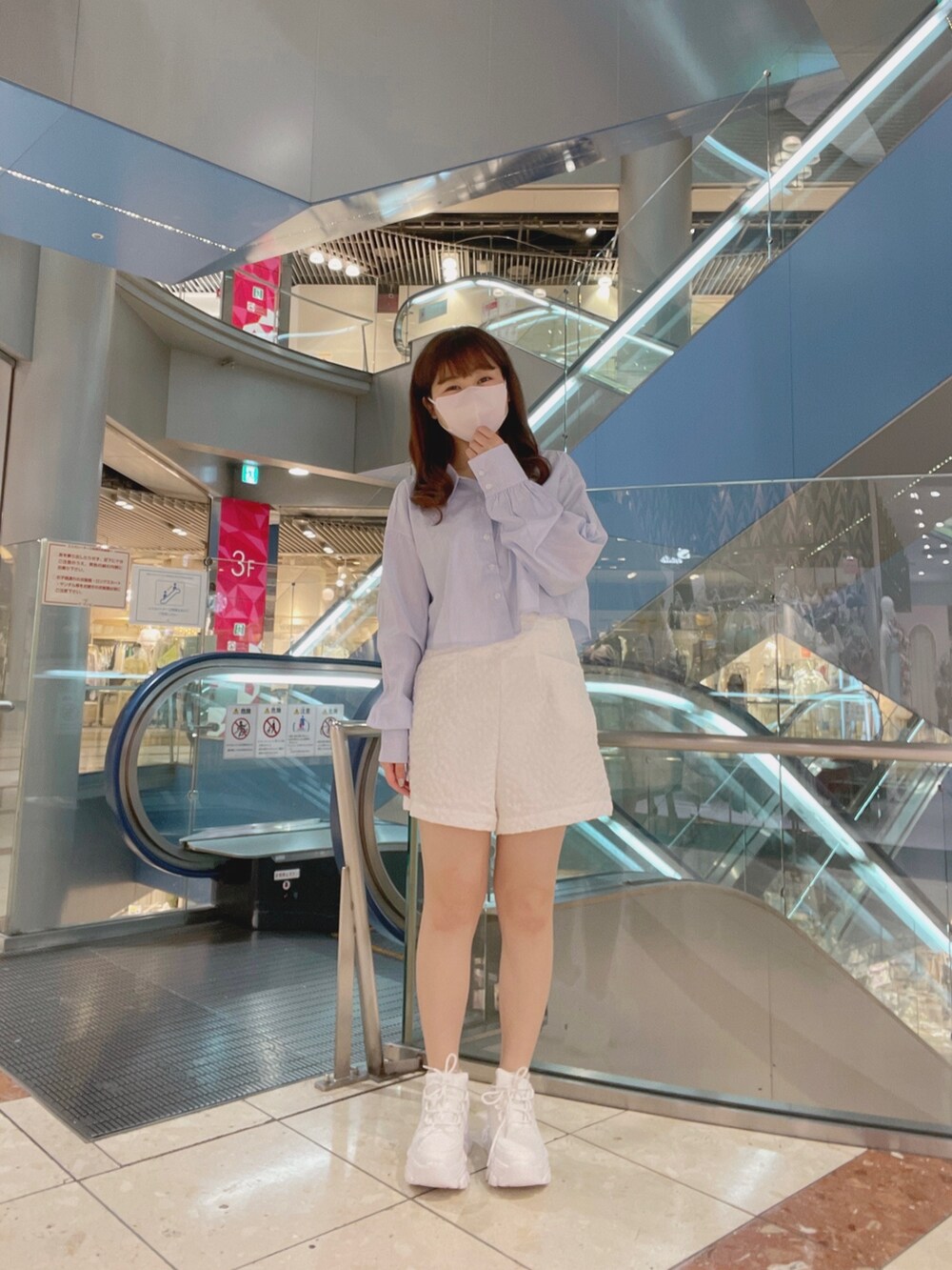 ホワイト系のスニーカー、ブルー系のトップス、ホワイト系のパンツを着用したレディースの春コーディネートの3枚目の写真