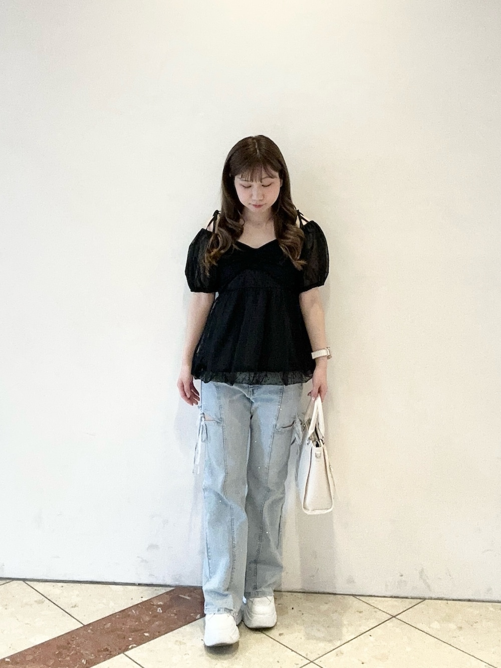 ブラック系のシャツ/ブラウス、ブルー系のデニムパンツ、ホワイト系のトートバッグを着用したレディースの春コーディネートの2枚目の写真