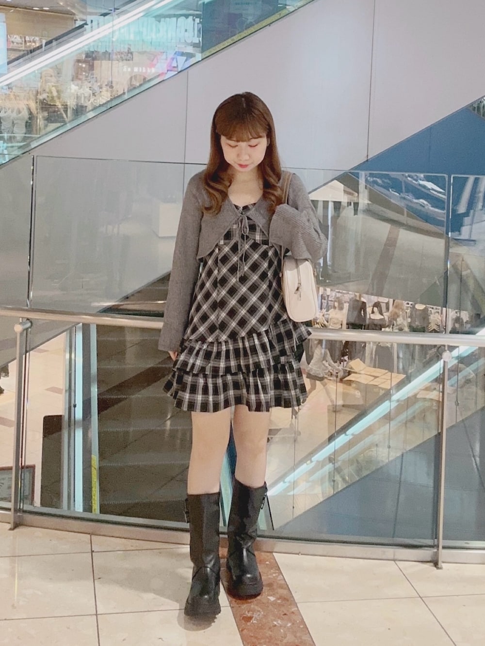 ブラック系のワンピース、ブラック系のブーツ、ホワイト系のボストンバッグを着用したレディースの秋コーディネートの2枚目の写真