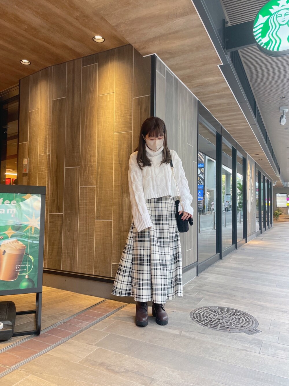 ホワイト系のニット/セーター、その他のスカート、ブラウン系のブーツを着用したレディースの冬コーディネートの2枚目の写真