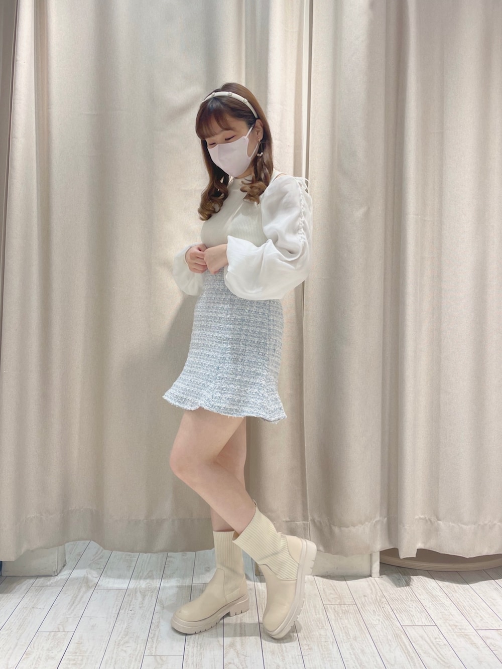 ホワイト系のニット/セーター、ブルー系のスカートを着用したレディースの冬コーディネートの3枚目の写真