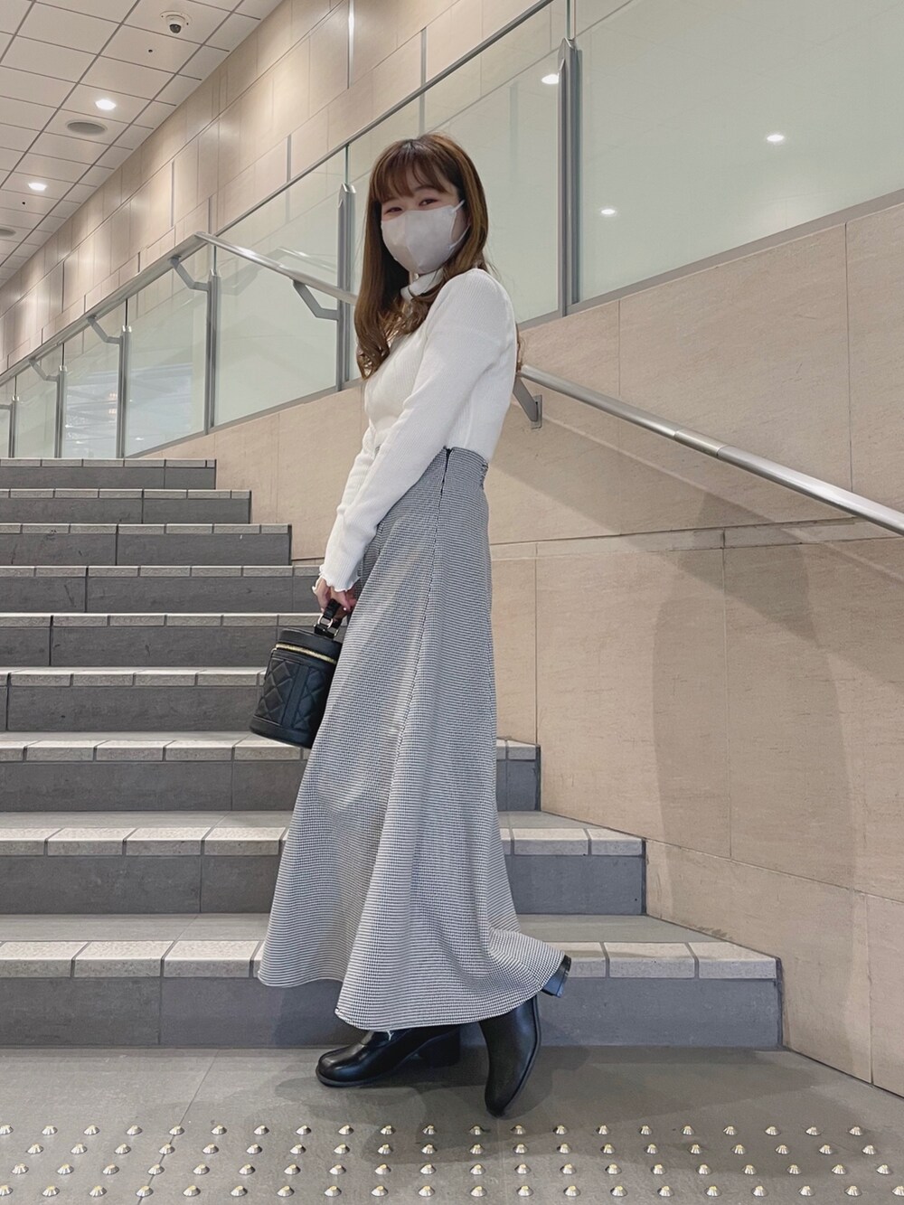 ホワイト系のニット/セーター、ブラック系のその他シューズ、その他のスカートを着用したレディースの冬コーディネートの3枚目の写真