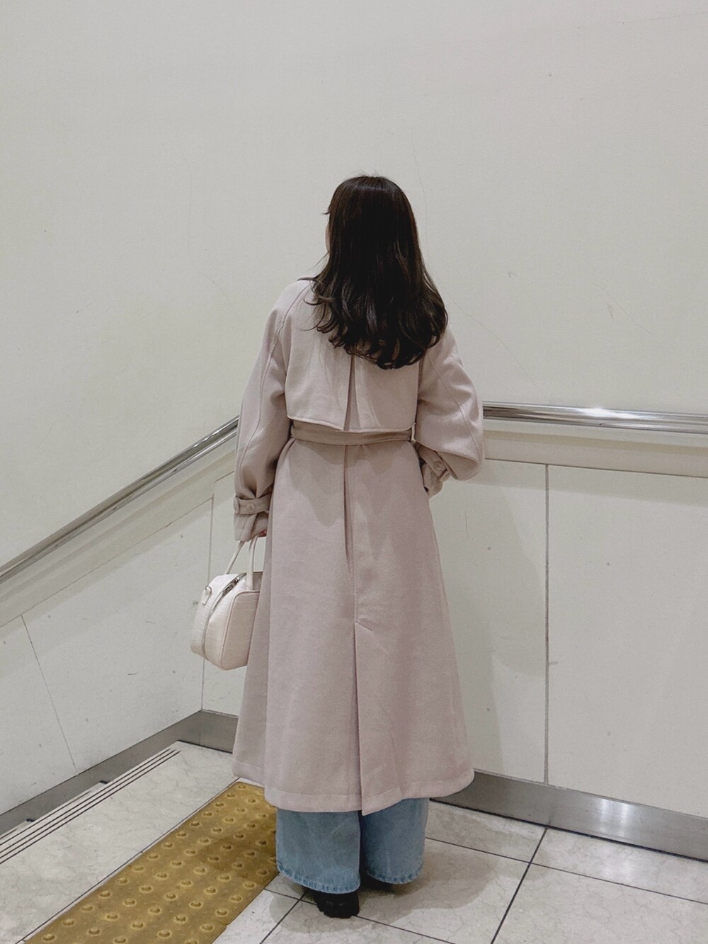 ホワイト系のショルダーバッグ、ホワイト系のニット/セーター、ホワイト系のステンカラーコートを着用したレディースの冬コーディネートの4枚目の写真