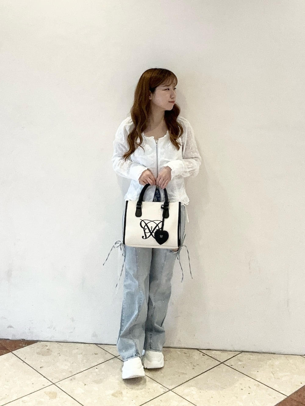 ホワイト系のシャツ/ブラウス、ブルー系のデニムパンツ、ホワイト系のトートバッグを着用したレディースの春コーディネートの2枚目の写真