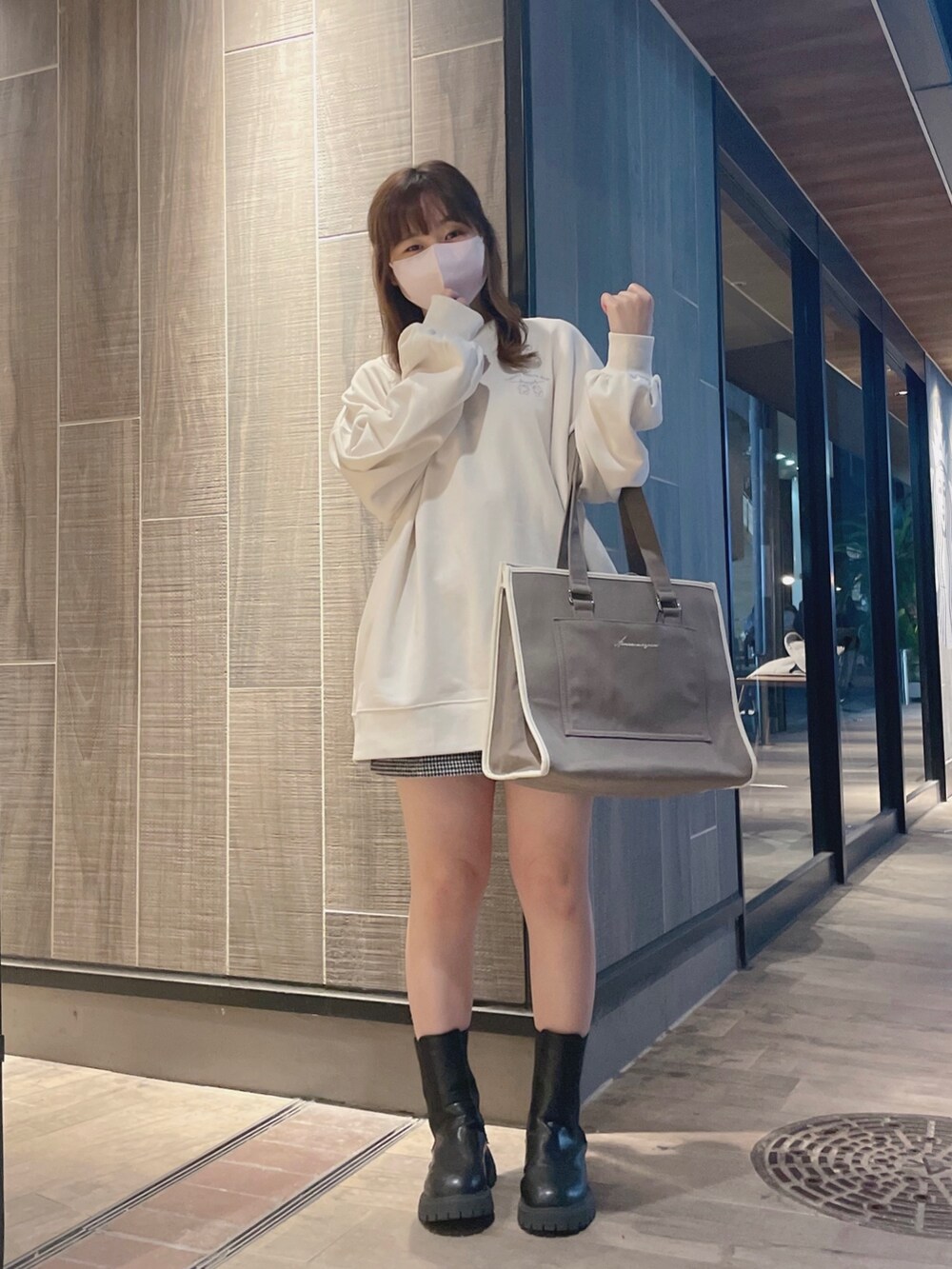 ホワイト系のスウェット、ブラウン系のトートバッグを着用したレディースの冬コーディネートの2枚目の写真