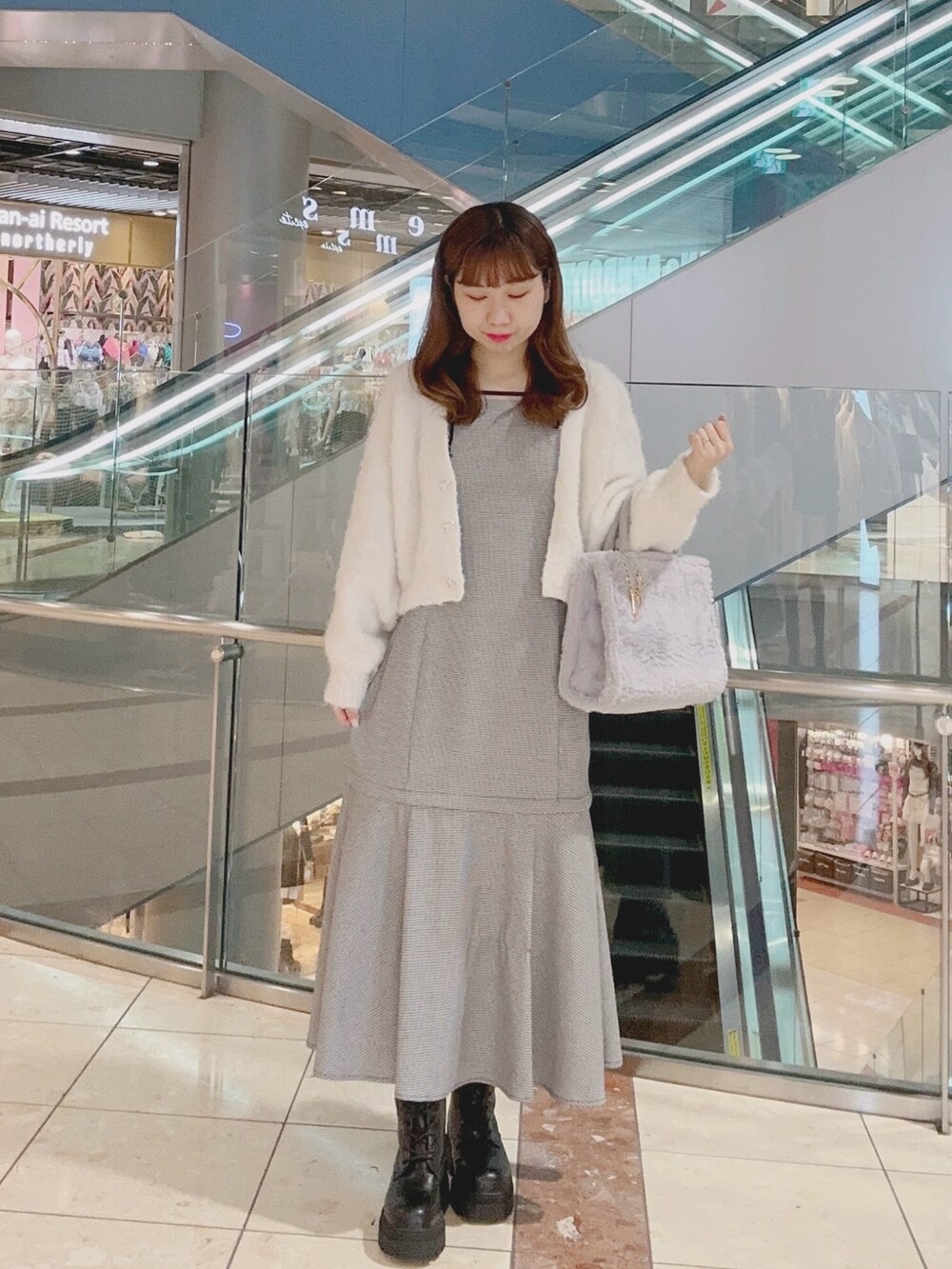 ブラック系のワンピース、ホワイト系のカーディガン/ボレロ、グレー系のトートバッグを着用したレディースの秋コーディネートの2枚目の写真