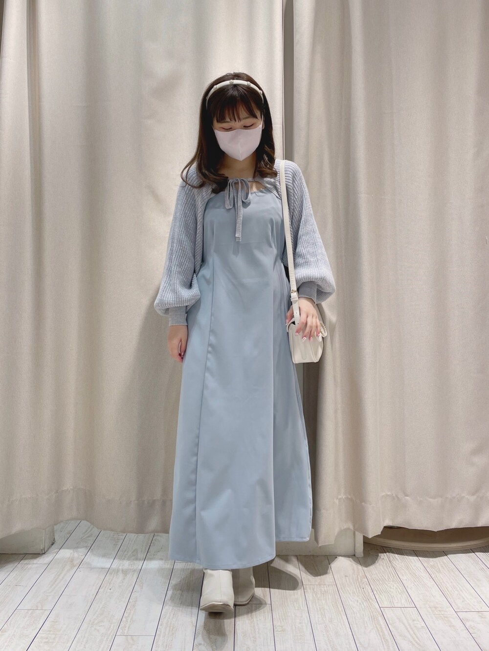 ホワイト系のショルダーバッグ、ブルー系のワンピースを着用したレディースの冬コーディネートの3枚目の写真