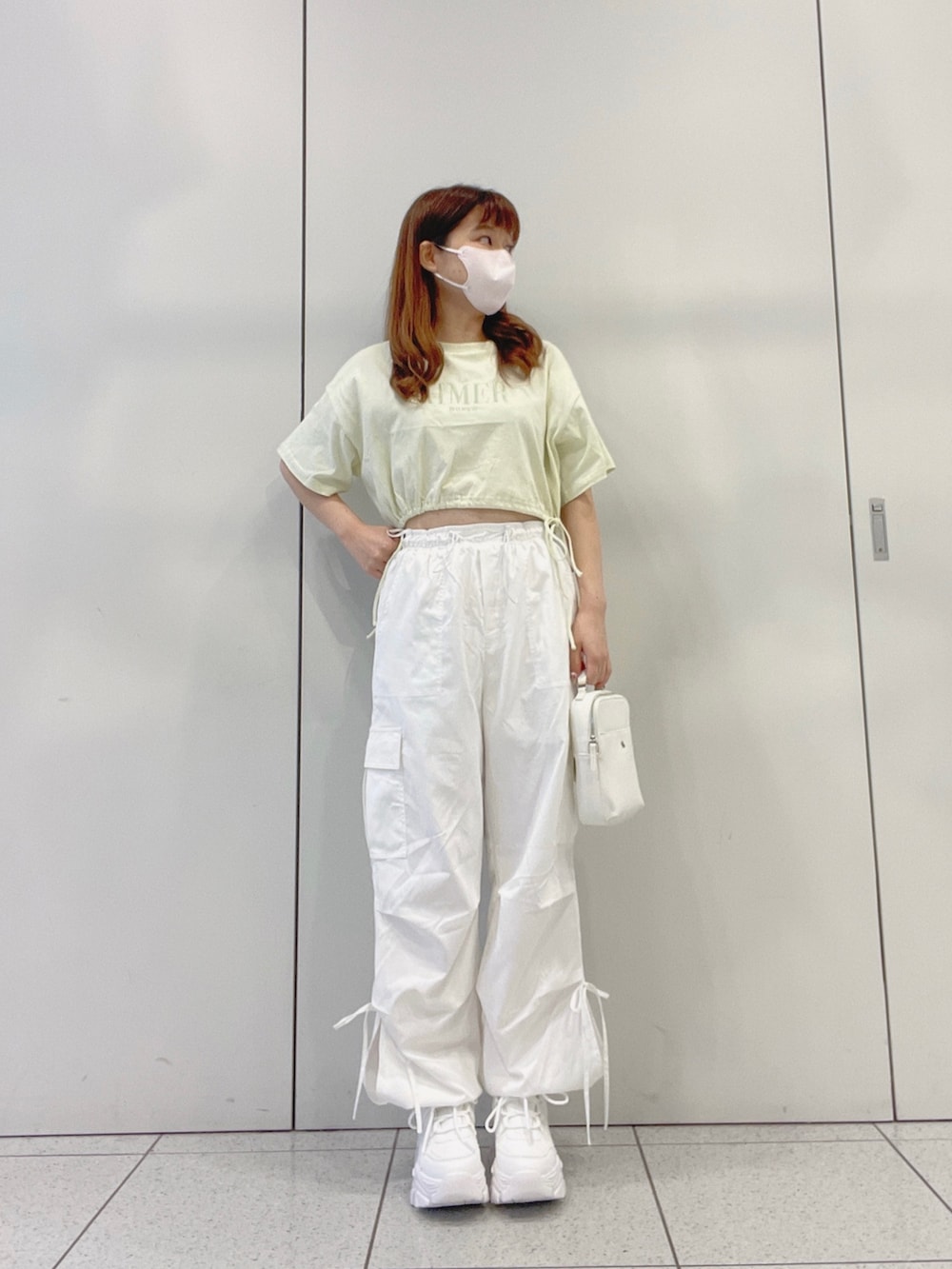 グリーン系のTシャツ/カットソー、ホワイト系のスニーカー、ホワイト系のカーゴパンツを着用したレディースの夏コーディネートの4枚目の写真