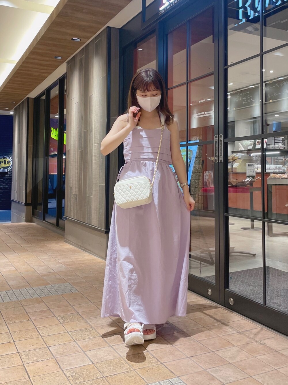 パープル系のワンピース、ホワイト系のショルダーバッグ、ホワイト系のサンダルを着用したレディースの夏コーディネートの2枚目の写真