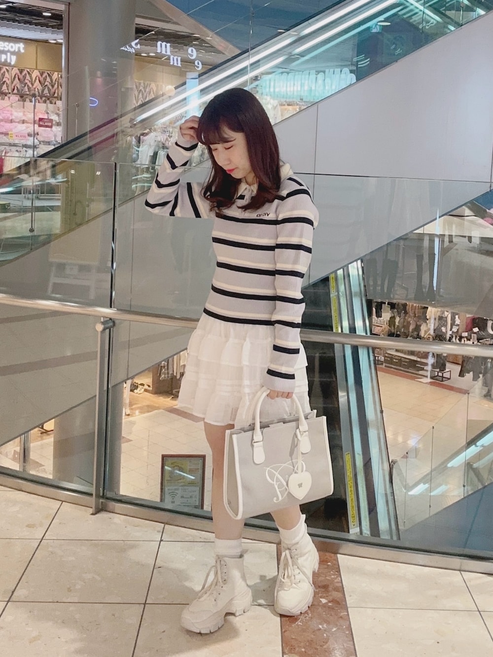 その他のニット/セーター、ホワイト系のスカート、ベージュ系のトートバッグを着用したレディースの冬コーディネートの2枚目の写真