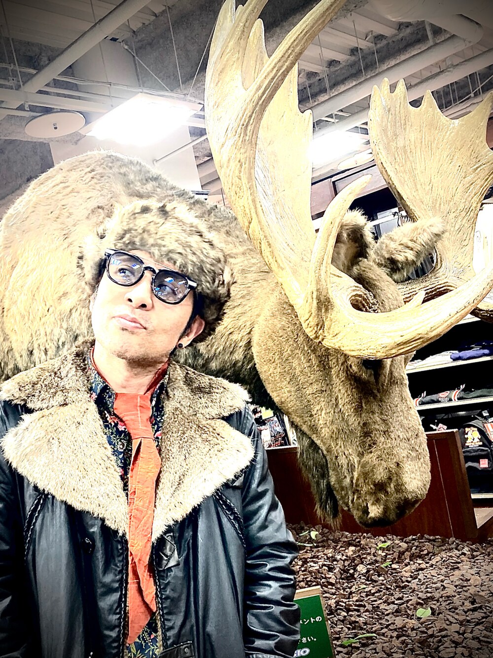 ブラック系のテーラードジャケット、ブラウン系のパンツ、レッド系のブーツを着用したメンズの冬コーディネートの4枚目の写真