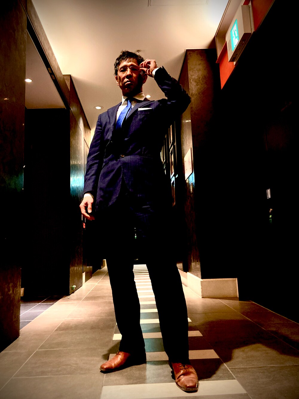 ブラック系のスーツセット、ブラック系のスーツパンツ、ブラウン系のドレスシューズを着用したメンズの春コーディネートの2枚目の写真