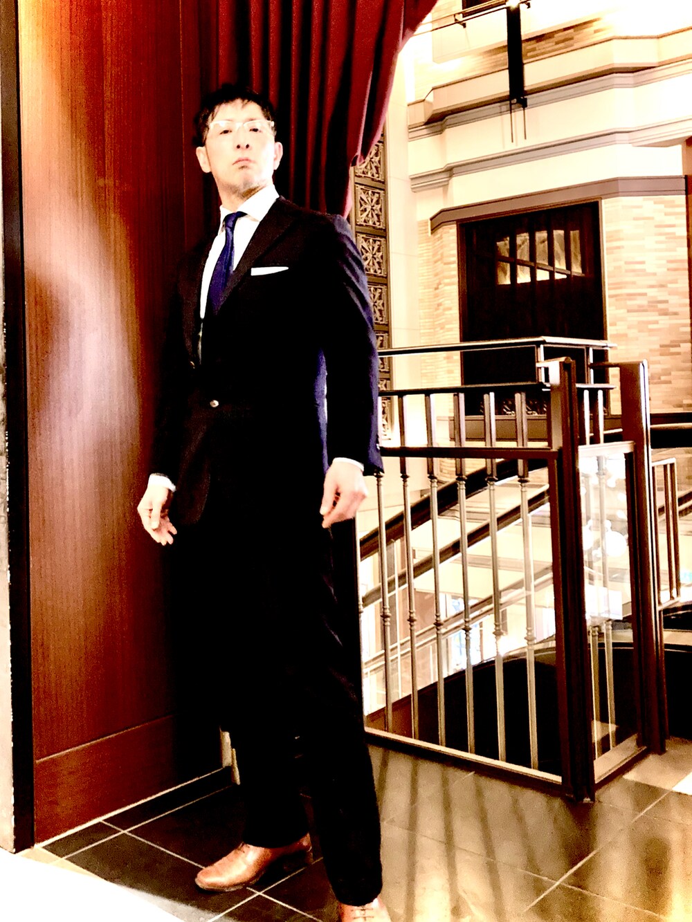 ブラック系のスーツセット、ブラック系のスーツパンツ、ブラウン系のドレスシューズを着用したメンズの春コーディネートの3枚目の写真