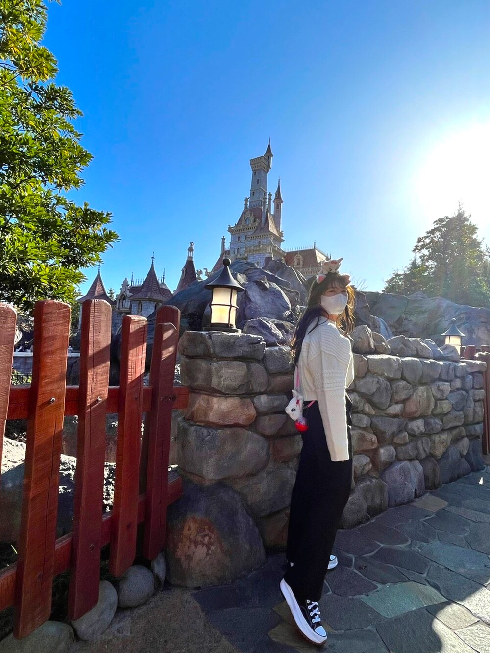 ブラック系のスラックス、ホワイト系のニット/セーターを着用したレディースの冬コーディネートの2枚目の写真