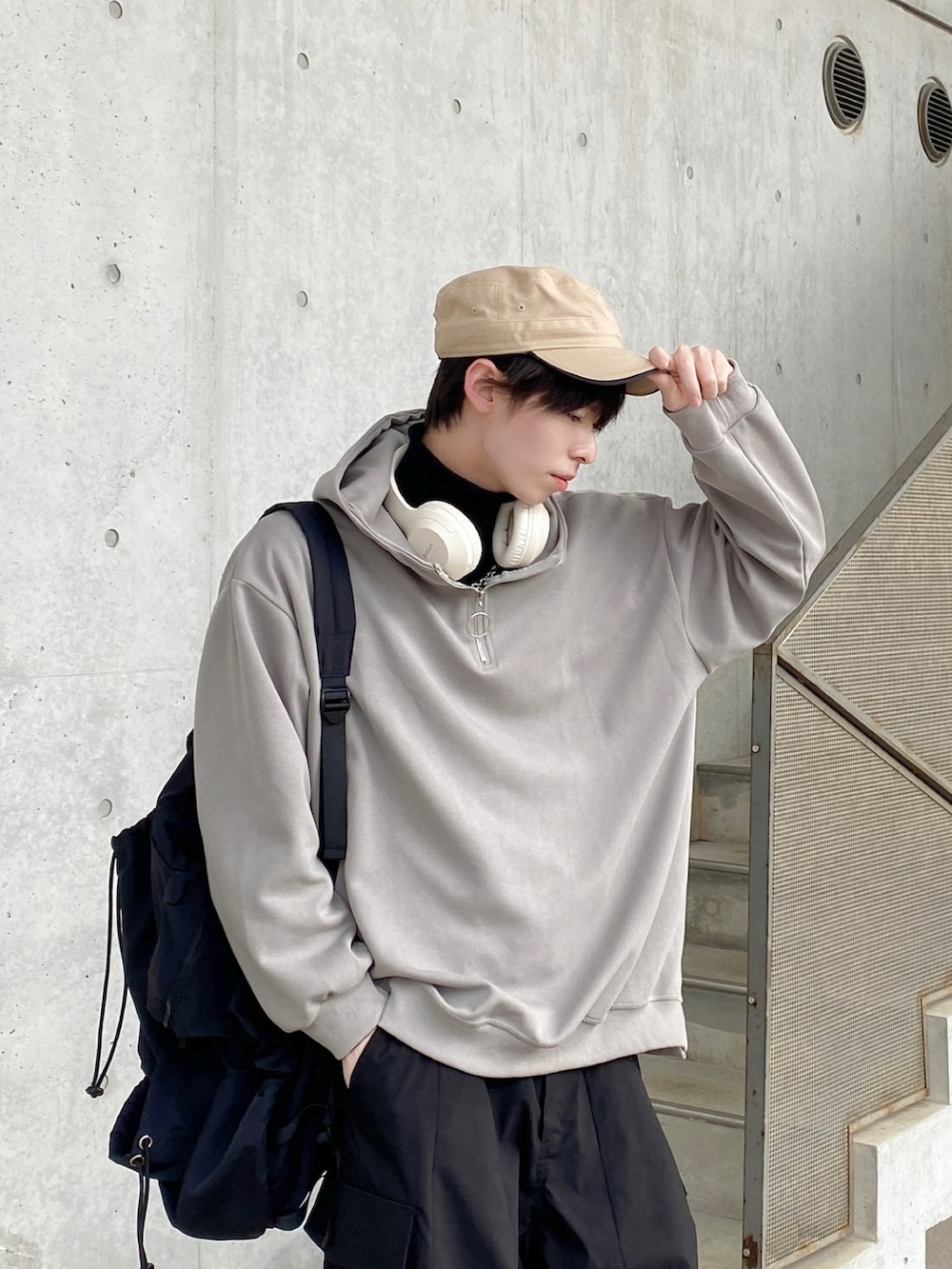 グレー系のパーカー、ブラック系のバックパック/リュック、ブラック系のカーゴパンツを着用したメンズの冬コーディネートの2枚目の写真