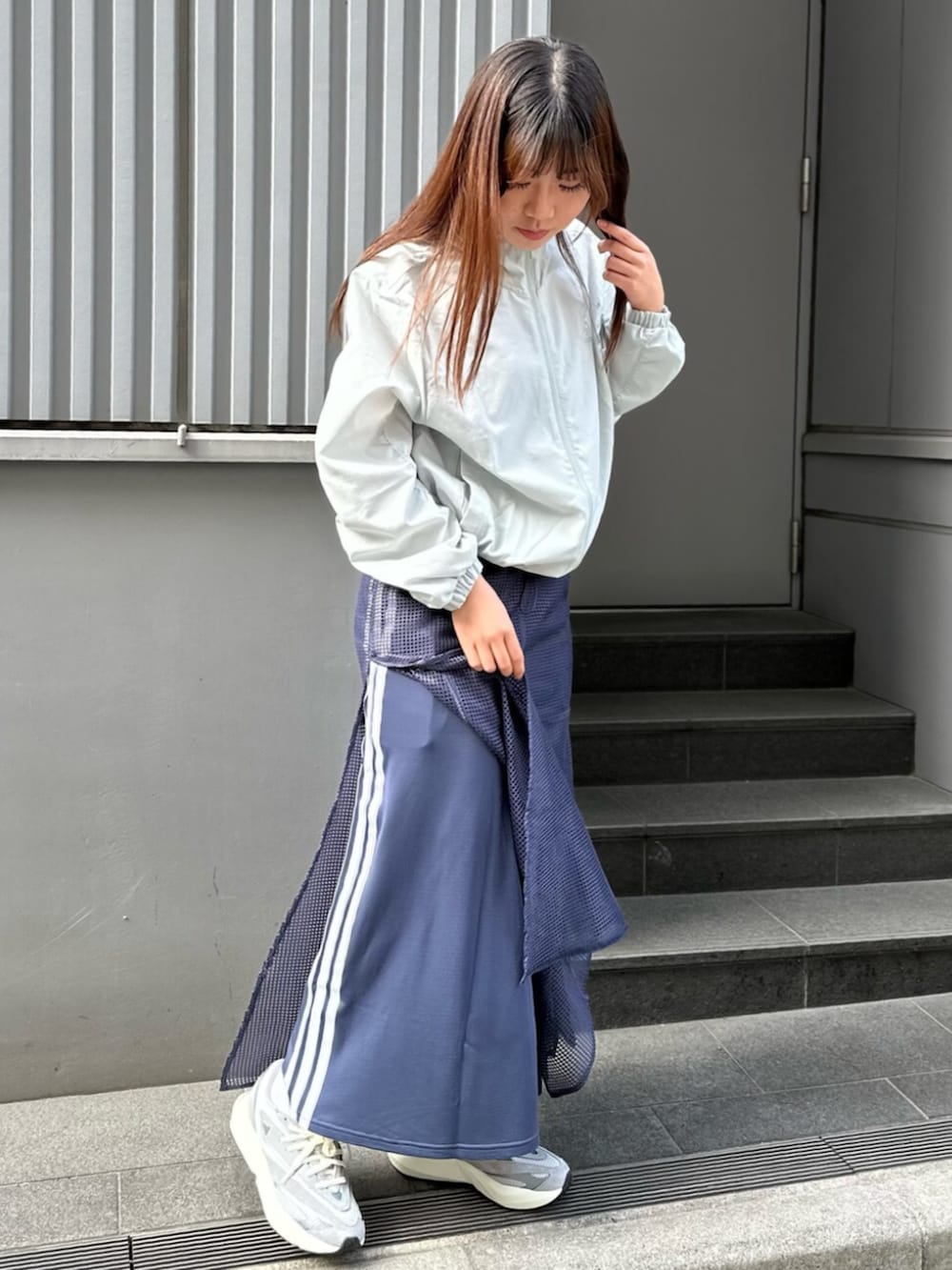 グレー系のスニーカー、ブルー系のスカートを着用したレディースの春コーディネートの3枚目の写真