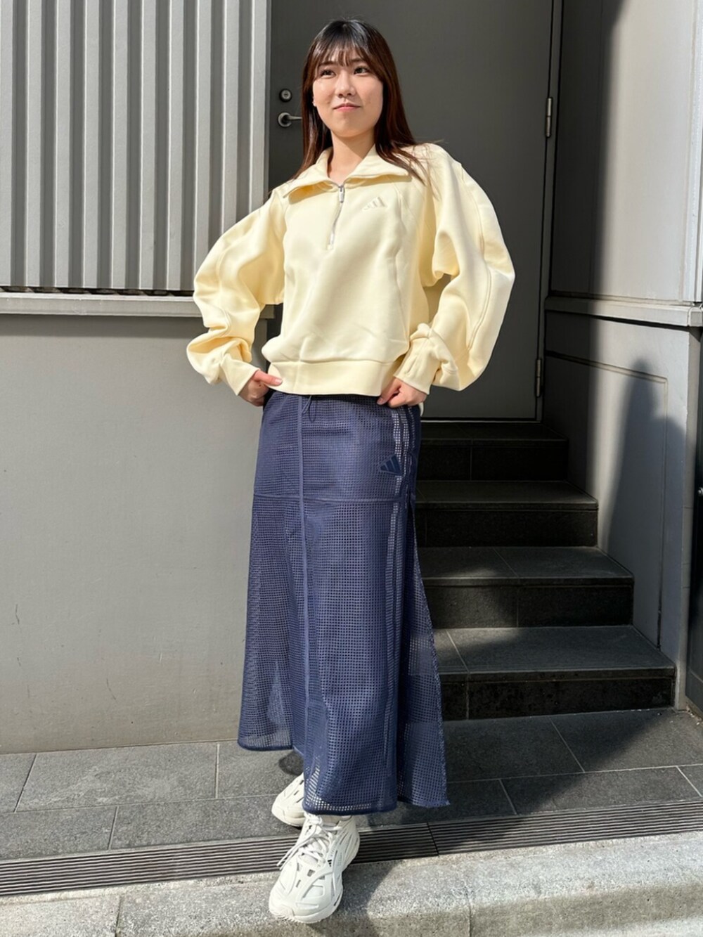 ブルー系のスカート、イエロー系のトップスを着用したレディースの春コーディネートの4枚目の写真