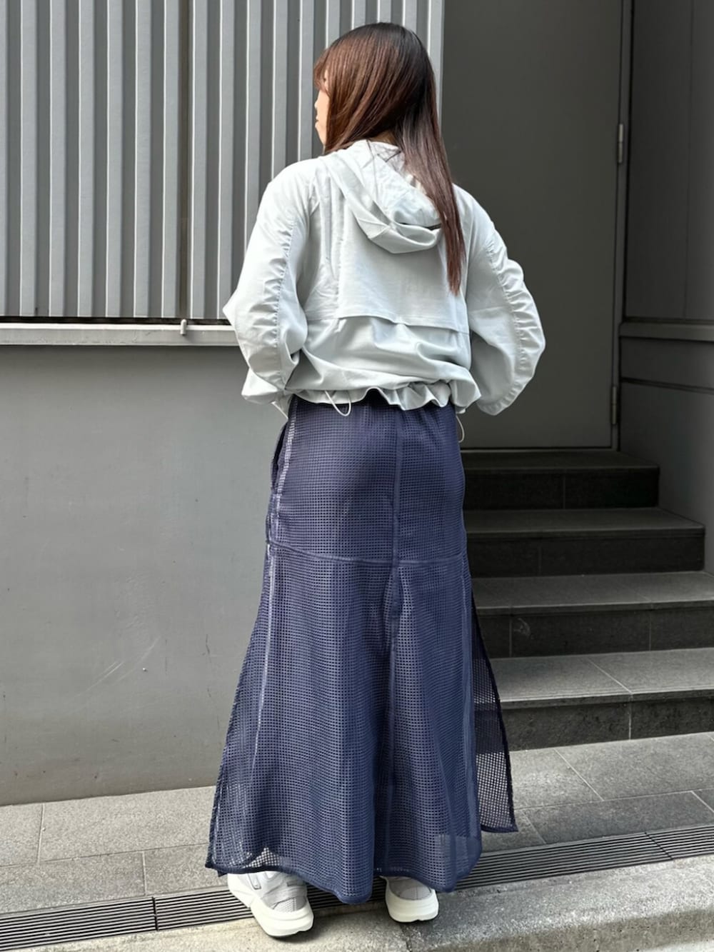 グレー系のスニーカー、ブルー系のスカートを着用したレディースの春コーディネートの4枚目の写真