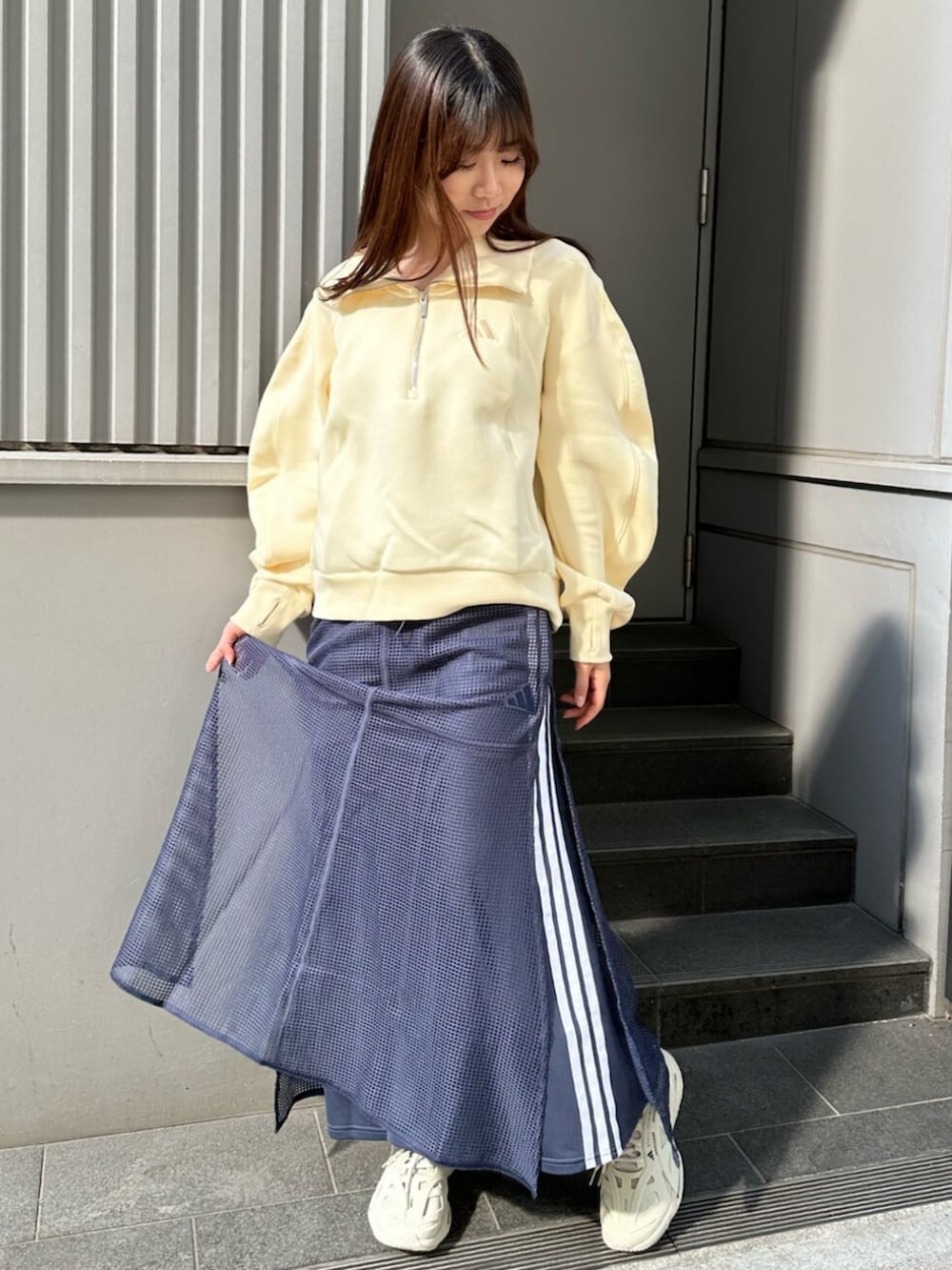 ブルー系のスカート、イエロー系のトップスを着用したレディースの春コーディネートの2枚目の写真