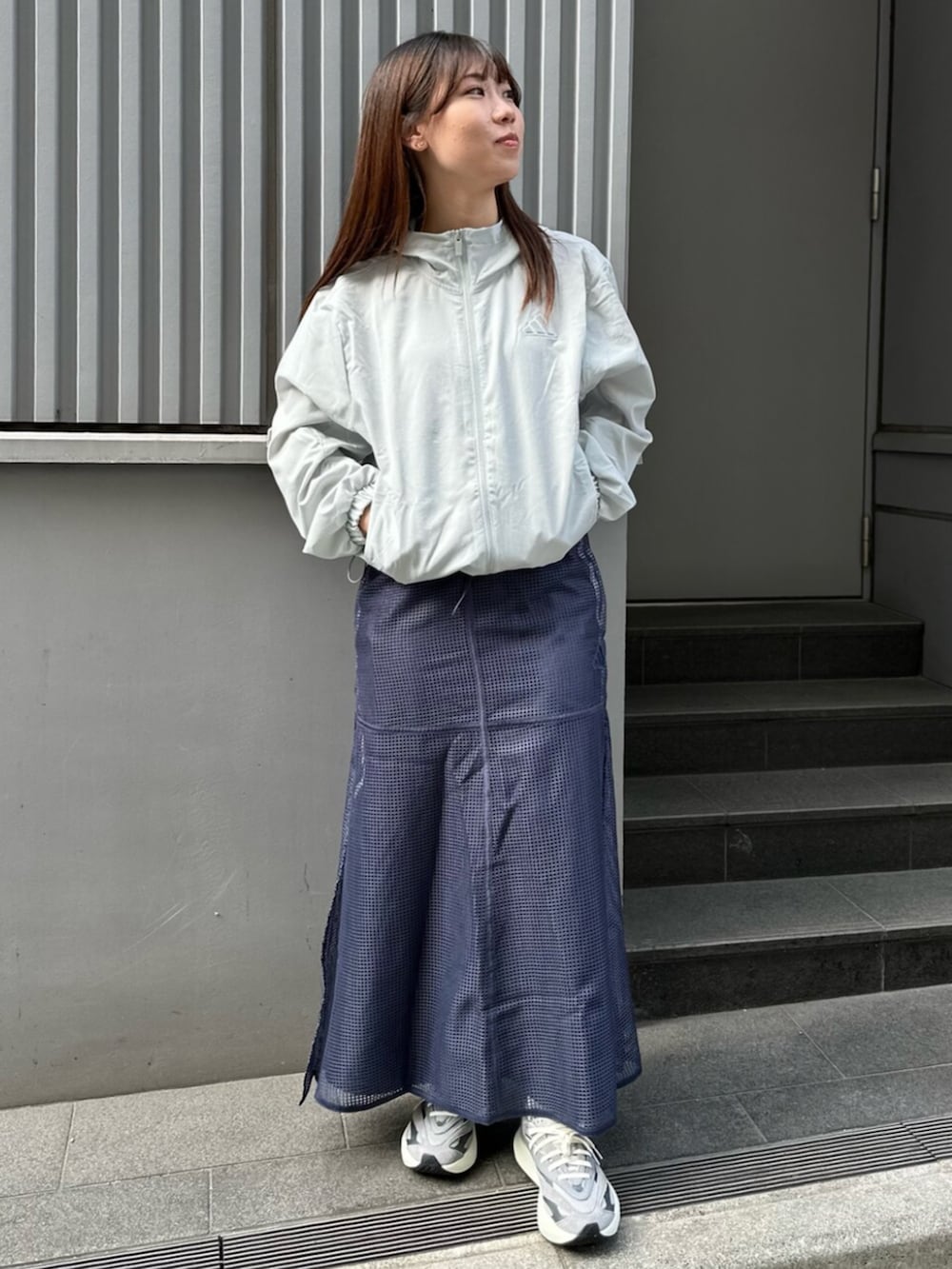 グレー系のスニーカー、ブルー系のスカートを着用したレディースの春コーディネートの2枚目の写真