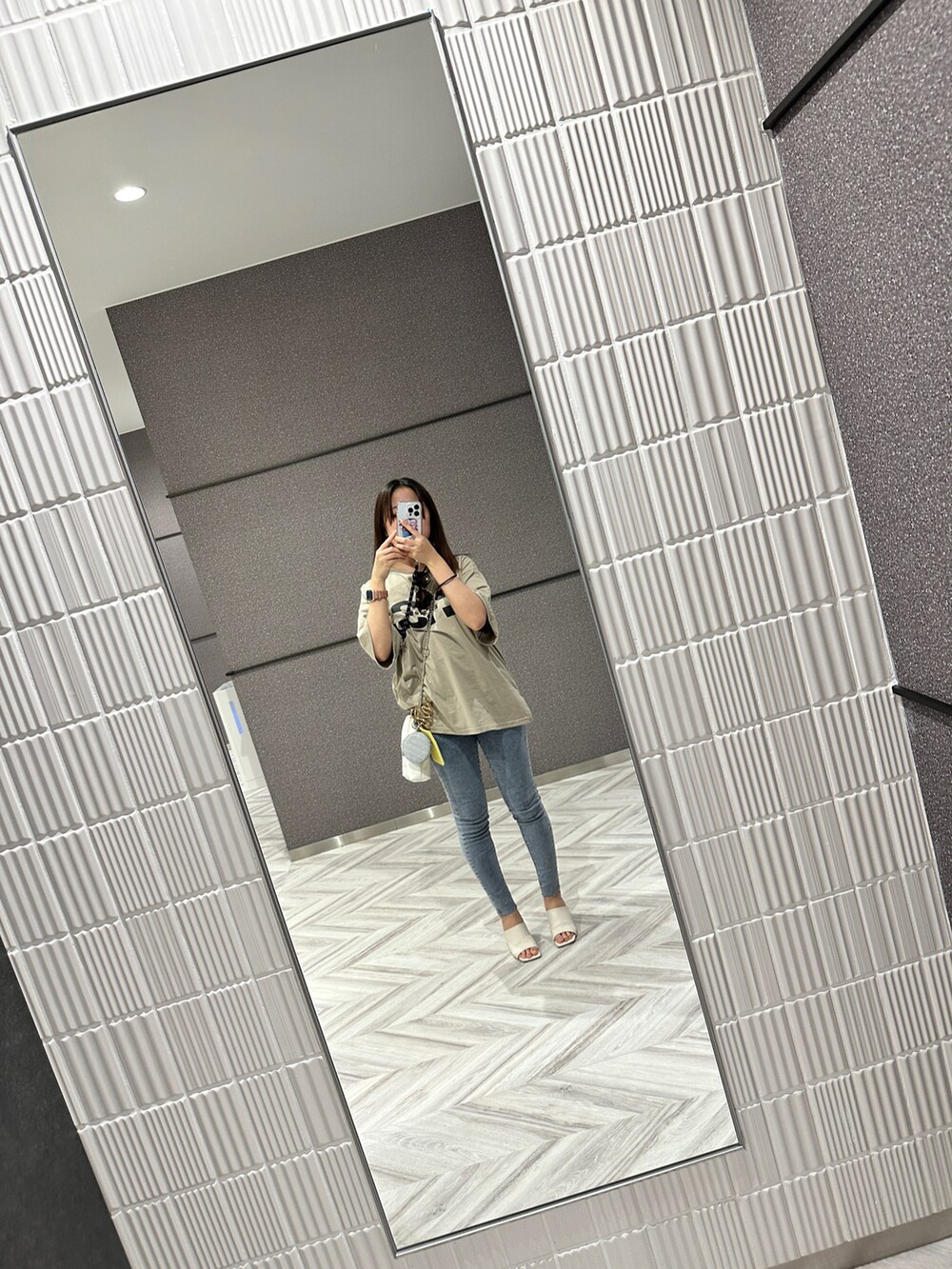 ホワイト系のサンダル、ホワイト系のショルダーバッグ、グリーン系のTシャツ/カットソーを着用したレディースの夏コーディネートの2枚目の写真