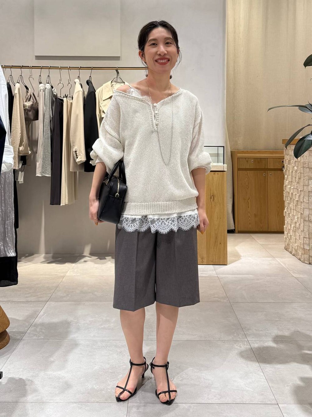 ブラック系のサンダル、グレー系のその他パンツ、ホワイト系のキャミソールを着用したレディースの春コーディネートの2枚目の写真