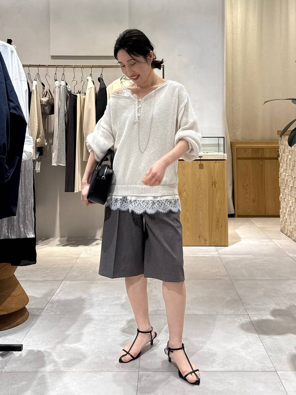 ブラック系のサンダル、グレー系のその他パンツ、ホワイト系のキャミソールを着用したレディースの春コーディネートの3枚目の写真