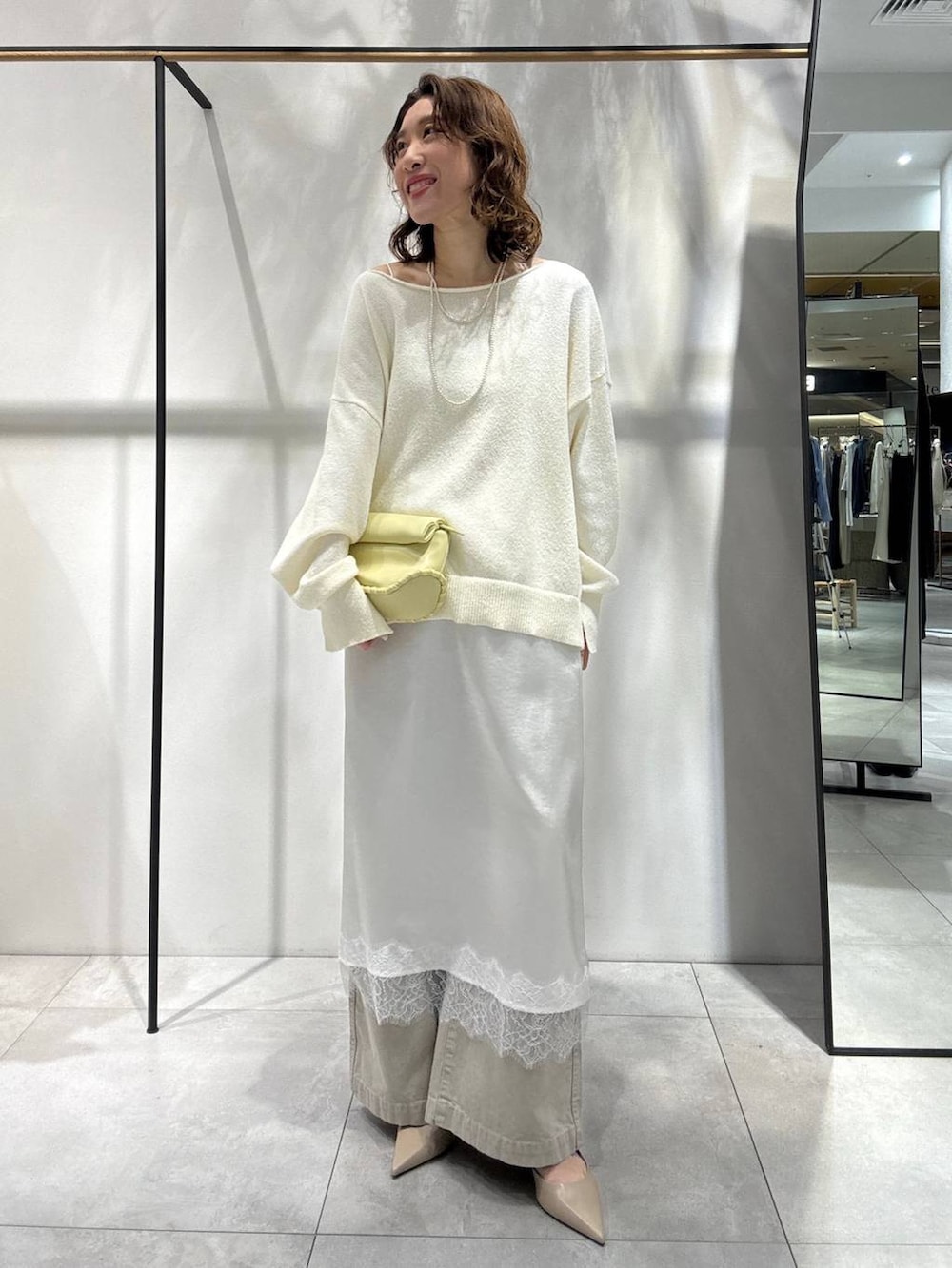 イエロー系のハンドバッグ、ベージュ系のその他パンツ、ベージュ系のトレンチコートを着用したレディースの春コーディネートの4枚目の写真