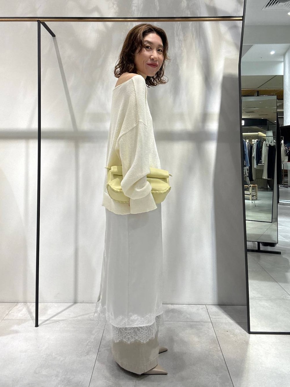 イエロー系のハンドバッグ、ベージュ系のその他パンツ、ベージュ系のトレンチコートを着用したレディースの春コーディネートの5枚目の写真