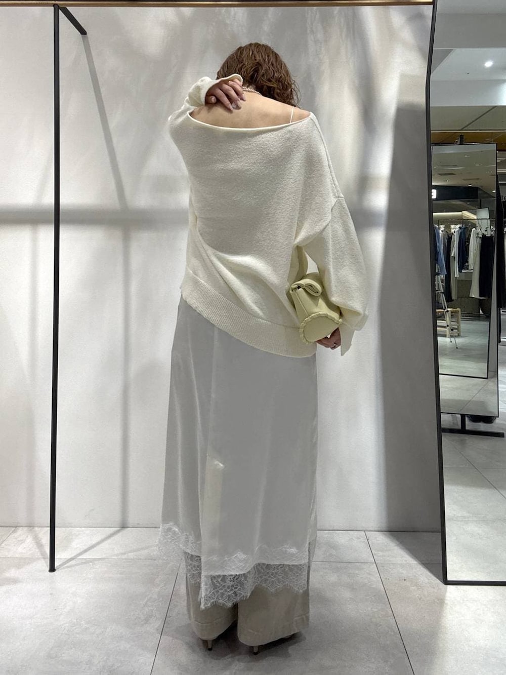 イエロー系のハンドバッグ、ベージュ系のその他パンツ、ベージュ系のトレンチコートを着用したレディースの春コーディネートの6枚目の写真