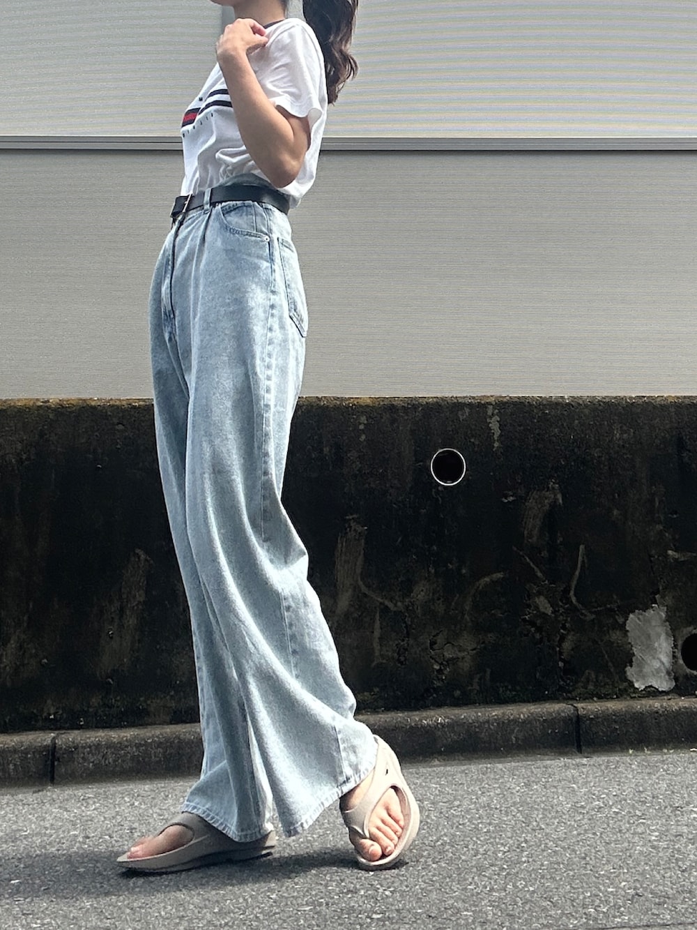 ホワイト系のTシャツ/カットソー、ブルー系のデニムパンツ、ベージュ系のサンダルを着用したレディースの春コーディネートの3枚目の写真