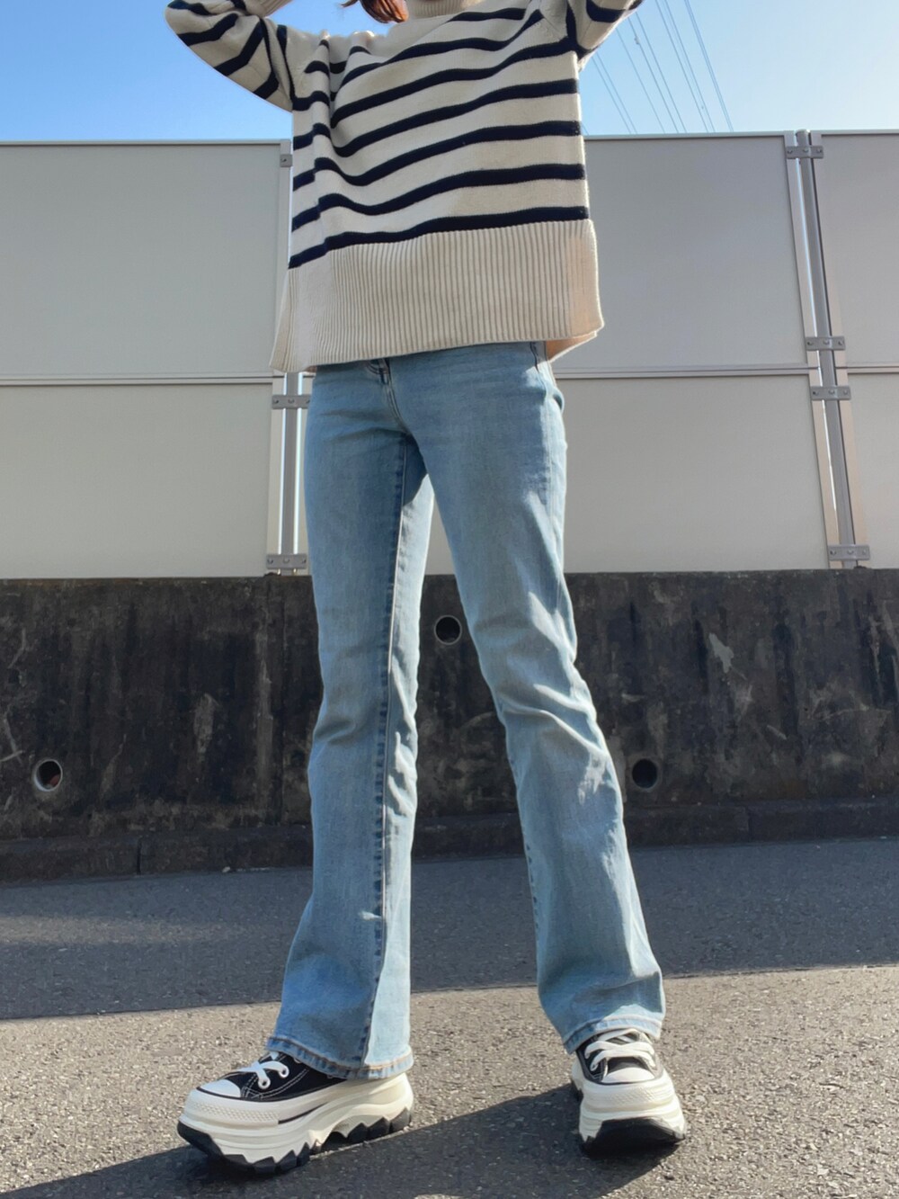 ブルー系のデニムパンツ、ブルー系のデニムジャケット、ホワイト系のニット/セーターを着用したレディースの春コーディネートの3枚目の写真