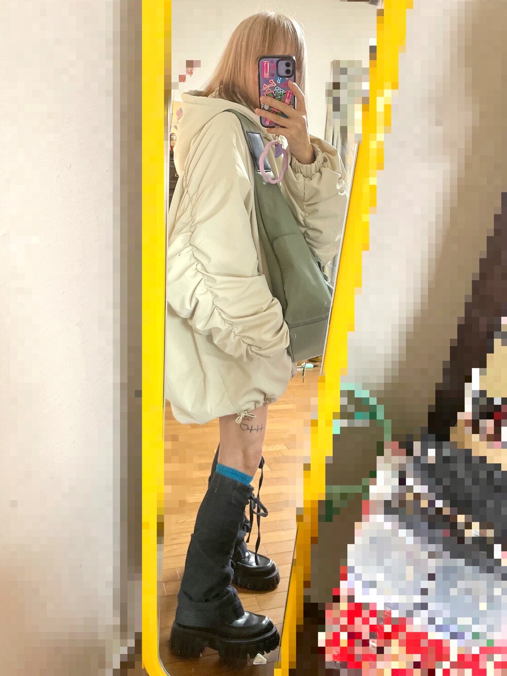 ホワイト系のその他アウター、グレー系のバッグ、ブラック系のレッグウォーマーを着用したレディースの冬コーディネートの2枚目の写真