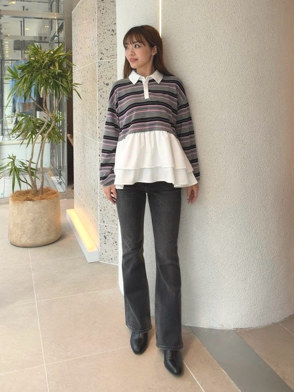 グレー系のニット/セーター、ブラック系のデニムパンツ、ブラック系のブーツを着用したレディースの秋コーディネートの6枚目の写真